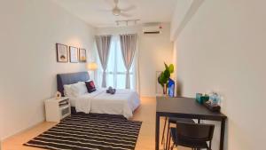 クアラルンプールにあるUNA Serviced Apartment by manatidurのベッドルーム1室(ベッド1台、デスク、テーブル付)