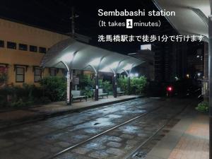 エスポアール新町Ⅵ(101) في Hanabatachō: محطة قطار في الليل مع مقاعد تحتها