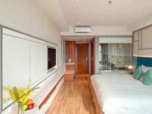 a bedroom with a large bed and a bathroom at Seaesta Nha Trang Hotel in Nha Trang