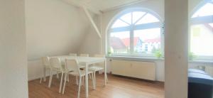 a white dining room with a white table and chairs at Monteurwohnung in Trossingen bei Villingen-Schwenningen in Trossingen