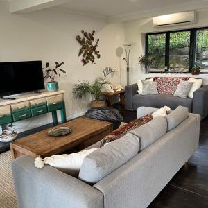 sala de estar con sofá y mesa de centro en Hillside Retreat Guest House, en Bli Bli