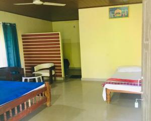 - une chambre avec 2 lits et 2 chaises dans l'établissement Hasiru Farms Homestay by StayApart, à Mudigere