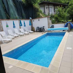 einen großen Pool mit Stühlen und einer Poolrutsche in der Unterkunft Хотел Марио in Mělník