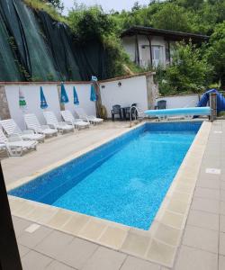 einen Pool mit Stühlen und einer Wasserrutsche in der Unterkunft Хотел Марио in Mělník