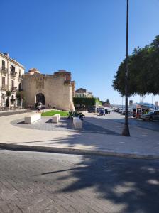 una calle con bancos y un edificio de fondo en Al Settimo porta marina en Siracusa