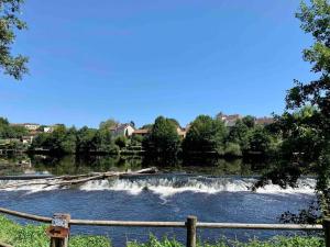 a river with a wooden fence and a waterfall at Studio 3 - Cinéma Sport Parking - DABNB in Limoges