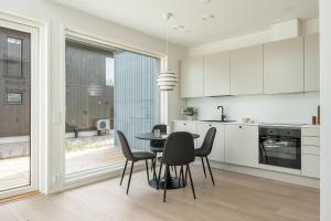 a kitchen and dining room with a table and chairs at Lovely Scandinavian Duplex for 6 and babybed in Vantaa Hiekkaharju Tikkurila in Vantaa