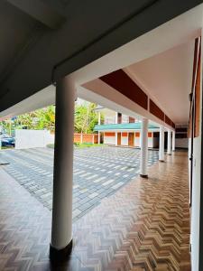 an empty patio with white columns in a building at Star Inn Plus in Kovalam