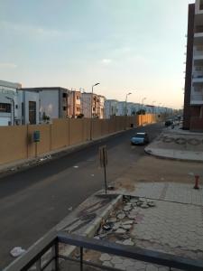 una calle vacía con coches aparcados a un lado de la carretera en دار مصر 