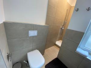 ein kleines Bad mit einem WC und einer Dusche in der Unterkunft English Romance Exclusive Apartments in Hannover