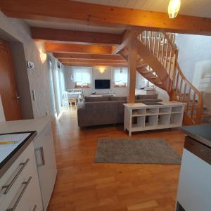 een keuken en een woonkamer met een bank en een trap bij Ferienwohnung RELAX in Neudrossenfeld