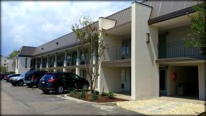 uma fila de carros estacionados em frente a um edifício em SureStay Plus by Best Western Covington em Covington