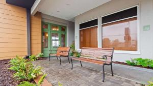 two benches sitting on a patio in front of a building at SureStay Plus by Best Western Covington in Covington