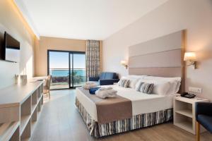 Una habitación de hotel con una cama grande y un escritorio. en Hotel Best Costa Ballena, en Costa Ballena