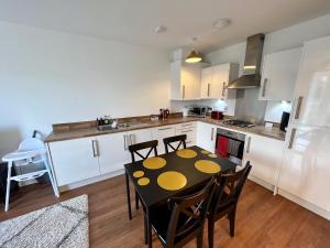 a kitchen with a table and chairs in a room at Fabulous Modern Apartment Close to Central Milton Keynes in Milton Keynes