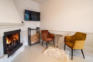 a living room with two chairs and a fireplace at The Pearl in Rīga