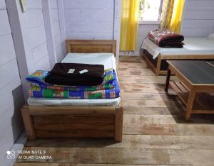 Zimmer mit 2 Etagenbetten und einem Tisch in der Unterkunft Rinzeebong Homestay by StayApart in Mangan