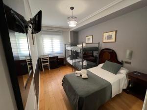 a bedroom with a bed and a tv in a room at Hospedium Plaza Mayor Salamanca in Salamanca