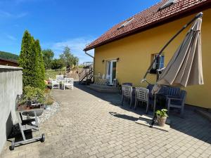 eine Terrasse mit einem Sonnenschirm und Stühlen sowie ein Gebäude in der Unterkunft Apartmány u Petry in Luhačovice