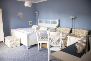 a blue room with a bed and chairs and a couch at Apartmány u Petry in Luhačovice