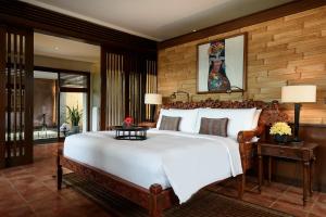 Tanah Gajah, a Resort by Hadiprana في أوبود: غرفة نوم مع سرير أبيض كبير في غرفة