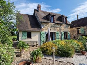 una vieja casa de ladrillo con un banco delante de ella en Maison Cosy - Normandie - Haras du Pin 30', en Fay