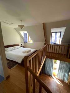 1 dormitorio con 1 cama y 2 ventanas en Maison Cosy - Normandie - Haras du Pin 30', en Fay