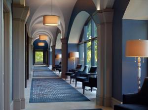 un pasillo en un hotel con sillas, mesas y ventanas en Hilton Atlanta Northeast, en Norcross