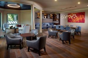 a restaurant with tables and chairs and a bar at Hilton Atlanta Northeast in Norcross