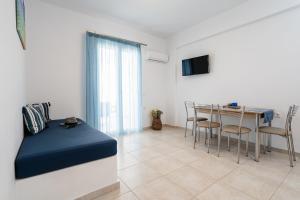 een woonkamer met een bed en een tafel met stoelen bij Evripus Suites in Kastraki Naxou