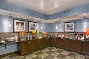 a restaurant with a counter with food on it at Hampton Inn State College in State College