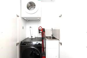 a kitchen with a washing machine and a sink at Metropol 3 • Comfy• Luxury• Central • Free Parking in Canberra