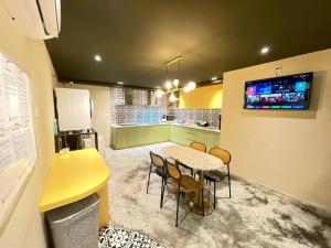 a kitchen with a table and chairs and a yellow counter at Swing & Pillows - Sungei Wang Hotel Bukit Bintang in Kuala Lumpur