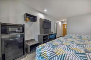 a hotel room with a bed and a flat screen tv at Motel 6-Fort Worth, TX - Burleson in Fort Worth