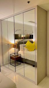 バンコクにあるSukhumvit13 Luxury suiteのベッドルーム(大きなガラスのクローゼット、ベッド付)