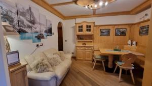 salon z kanapą i biurkiem w obiekcie Alex w mieście Campitello di Fassa