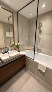 een badkamer met een bad, een wastafel en een bad bij DOM Boutique Apartments - Verde in Belgrado