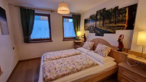 sypialnia z łóżkiem i dwoma oknami w obiekcie Alex w mieście Campitello di Fassa +1 zdjęcie