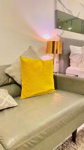 a yellow pillow sitting on a couch in a room at Sukhumvit13 Luxury suite in Bangkok