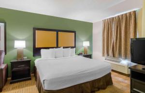 a hotel room with a bed and a flat screen tv at Extended Stay America Suites - Richmond - W Broad Street - Glenside - North in Richmond