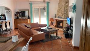 Una sala de estar con un sofá y una chimenea. en Villa Casira, 6 personen, Viñuela, Andalucía, en Viñuela