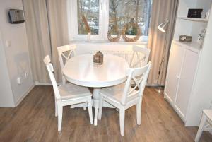 een witte tafel en stoelen in een kamer met een raam bij Bett u Butze Timmendorfer Strand Ferienwohnung in Timmendorfer Strand