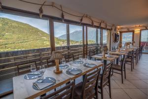 una fila de mesas en un restaurante con montañas en Una Finestra Sulle Alpi, en Bema