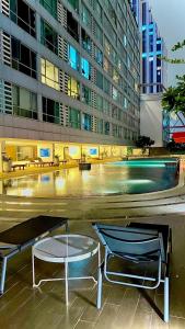 two chairs and a pool in front of a building at Sukhumvit13 Luxury suite in Bangkok