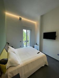 a bedroom with a large bed and a television at B&B Un Passo Dal Treno Piazza Vittorio Veneto 36-Salerno Station-Building under renovation in Salerno +23 photos