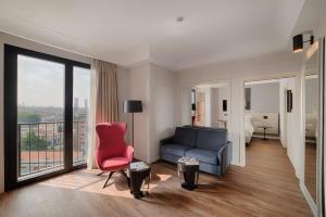 a living room with a couch and a bed and a window at Radisson Blu Hotel Milan in Milan