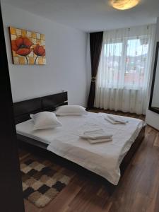 a bedroom with a large bed with white sheets at Drag De Munte in Predeal