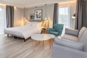 um quarto de hotel com uma cama, um sofá e uma mesa em Radisson Hotel Kaunas em Kaunas