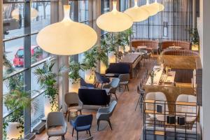 a restaurant with chairs and tables and large windows at Radisson Hotel Kaunas in Kaunas