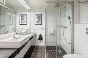 a bathroom with a sink and a shower at Radisson Hotel Kaunas in Kaunas